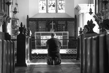 Man kneeling at the alter of a holy place