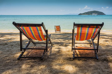 sun beach chairs on shore near sea.