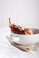 Pear poached in white wine with chocolate sauce and nuts