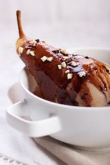 Pear poached in white wine with chocolate sauce and nuts