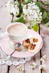 Shortbread cookies with white chocolate and walnuts and a Cup of coffee with milk.
