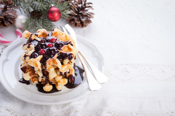 Waffles with chocolate sauce and winter berries for christmas.
