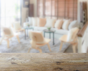 wooden table top with blur of modern living room interior as bac