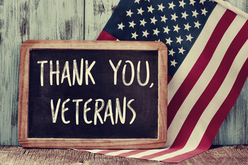 tekst bedankt veteranen in een schoolbord en de vlag van de VS