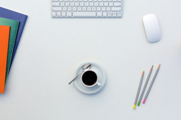 Creative Office Bright Table with Color Magazines and Pencils Computer and Coffee Mug