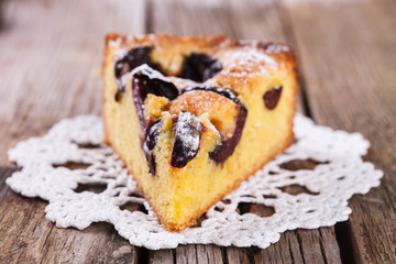 A piece of plum cake in powdered sugar
