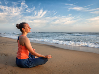 Fototapeta na wymiar Young sporty fit woman doing yoga oudoors at beach