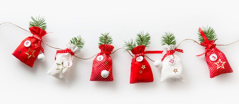 6 Säckchen vom Adventskalender hängende Weihnachtsdekoration zur Weihnachtszeit, traditionell deutsche Weihnachtsgestaltung.