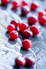 Wet cranberry  on a dark stone wet background, selective focus a