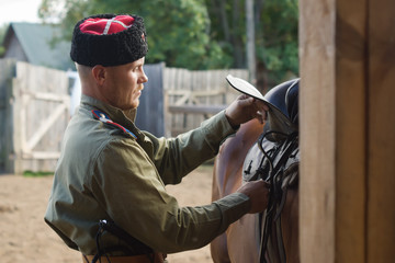 Fototapeta premium Cossack grooming horse in the stall