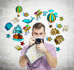 A portrait of handsome tourist in casual clothes who holds a camera. Summer vacation icons are...