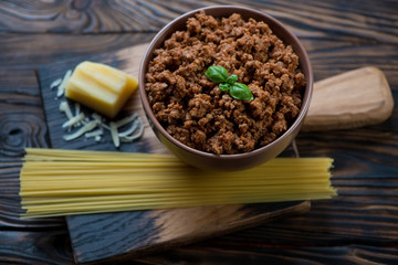 Ingredients for spaghetti bolognese on a rustic cutting board