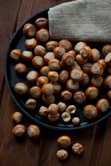 Top view of hazelnuts in a frying pan, close-up, studio shot