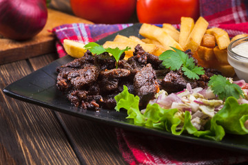 Kebab of beef with french fries and salad