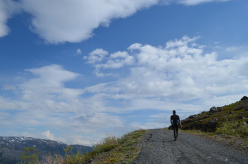 Man hiking on gravel roads in subarctic Norwegian mountains