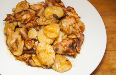 Octopus with paprika and potatoes on a white plate, also known a