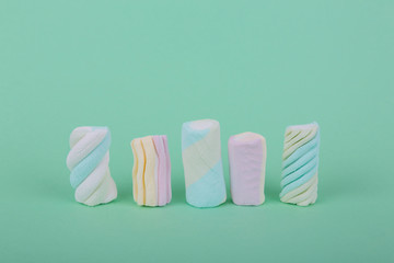 marshmallow candies vertically and horizontally, side view close-up on a turquoise background.