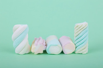 marshmallow candies vertically and horizontally, side view close-up on a turquoise background.