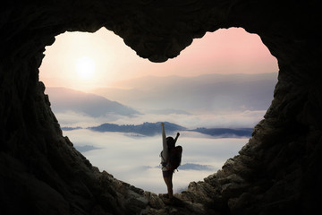 Backpacker in cave enjoy mountain view