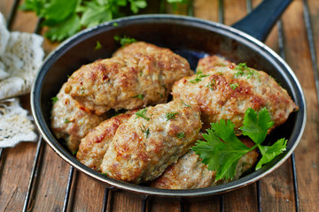 Minced meat kebab in a frying pan, top view