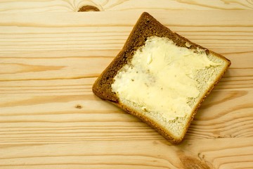 Toast with butter on wooden background