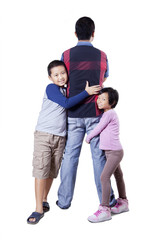 Two children embracing their father in the studio