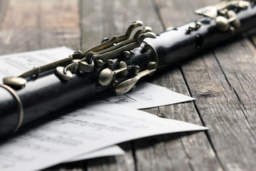 Old black flute and music notes on rusty wooden table
