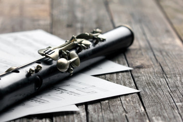 Naklejka premium Old black flute and music notes on rusty wooden table