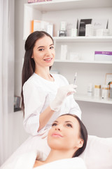Attractive female cosmetologist is serving her customer
