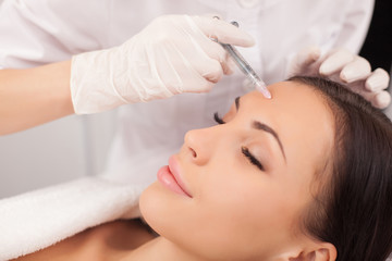 Professional cosmetologist is making procedure at clinic
