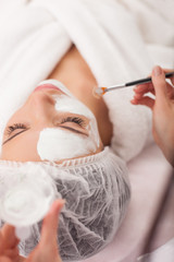 Skillful cosmetician is serving her female customer
