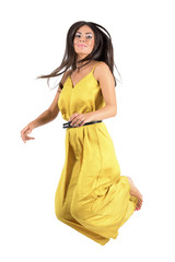 Young fashion model in yellow dress jumps in mid air. 