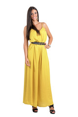 Fototapeta premium Smiling posing fashion beauty in yellow jumpsuit with hand on her hip isolated