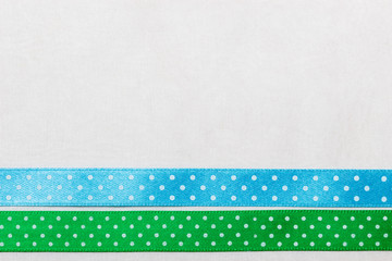 Dotted green blue ribbon frame on white cloth
