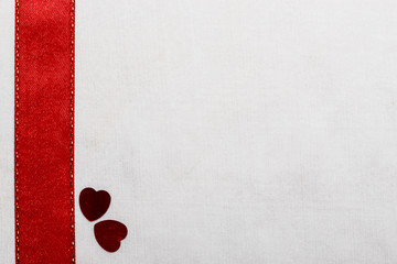  Red satin ribbon hearts on white cloth.
