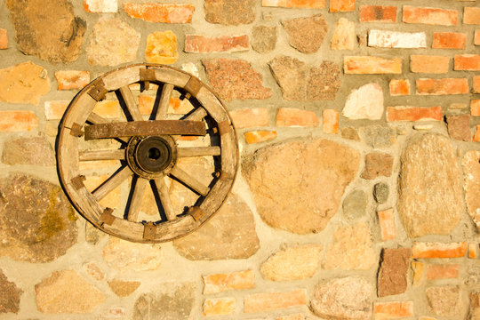 Old wooden wheel hanging on the wall.