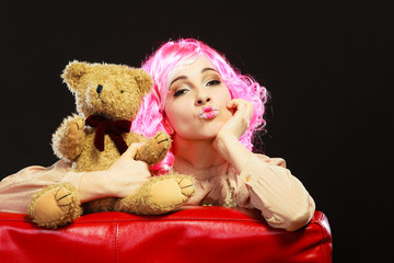 childlike woman and teddy bear sitting on couch