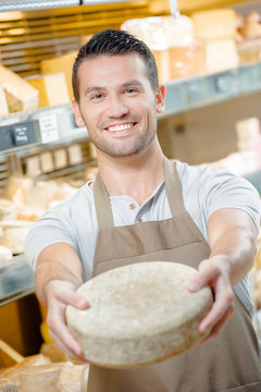 Shop assistant holding cheese