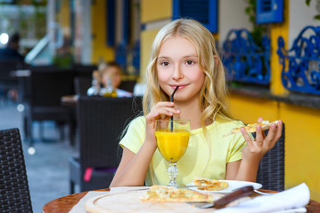 Pretty girls smiling when drinking juice and eating pizza