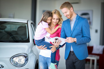 car dealer showing brochure young woman with child