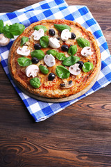 Tasty pizza with vegetables and basil on table close up