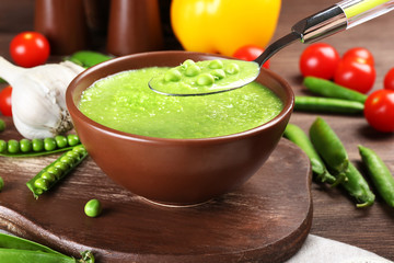 Tasty peas soup and vegetables on table close up