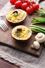 Baked potatoes with cheese and mushrooms on table close up
