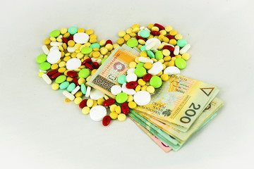 Tablets, medicines arranged in a heart shape with banknotes - obrazy, fototapety, plakaty