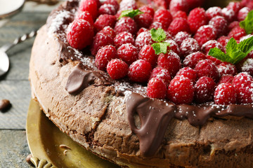 Cake with Chocolate Glaze and raspberries on wooden background