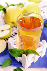 Glass of apple juice with fruits and fresh mint on table close up