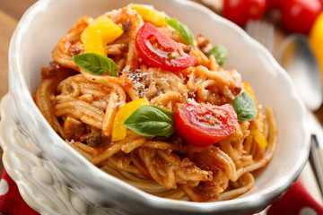 Homemade Spaghetti Bolognese with parmesan cheese in white bowl, on color wooden background