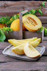 Ripe melons with green leaves on table close up