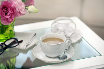 Cup of coffee on table in living room