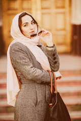 girl in a coat posing on building background